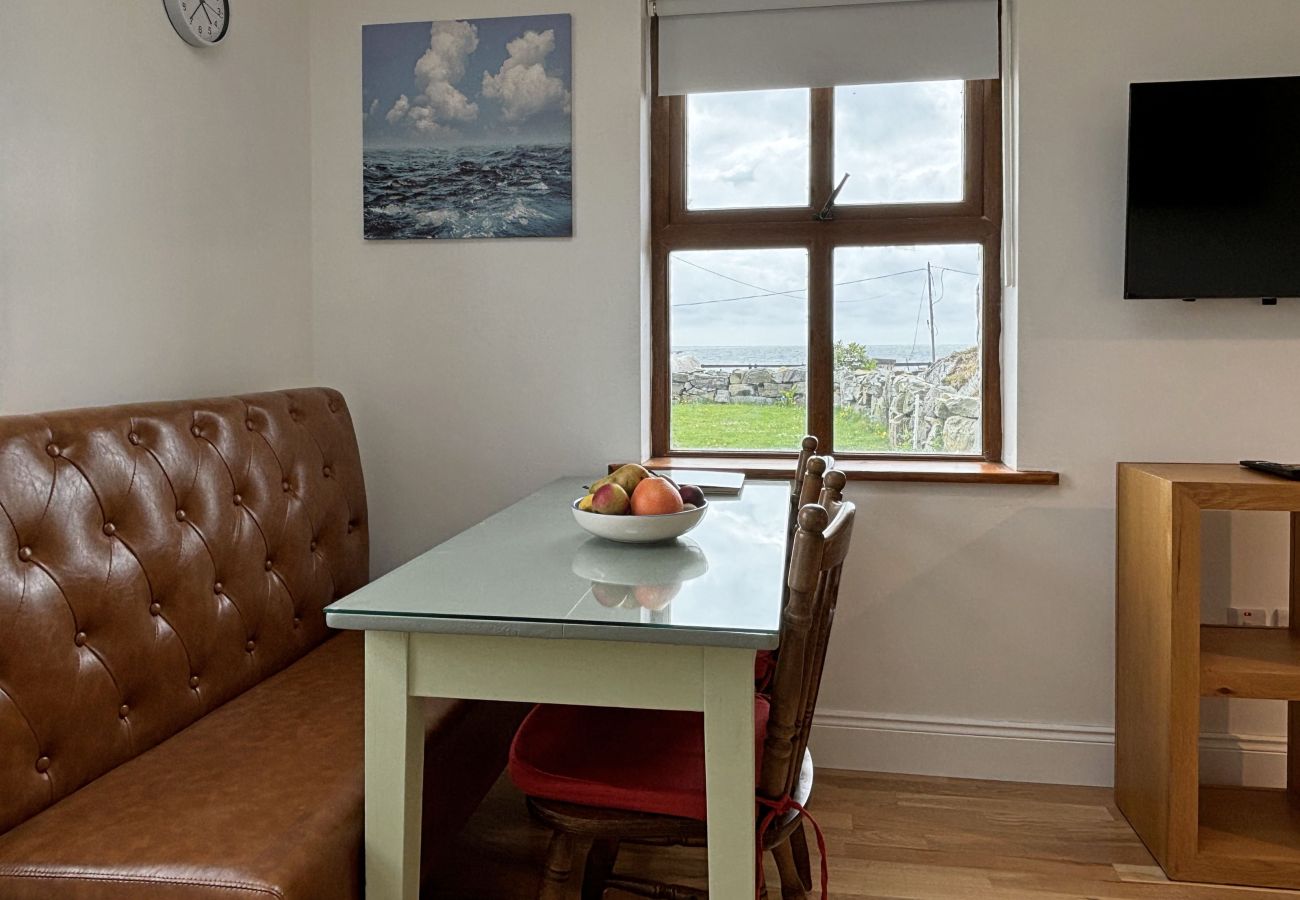 Clifden Holiday Apartment. Compact dining area, seating for 4 with beautiful views. Quaint, cottage style.