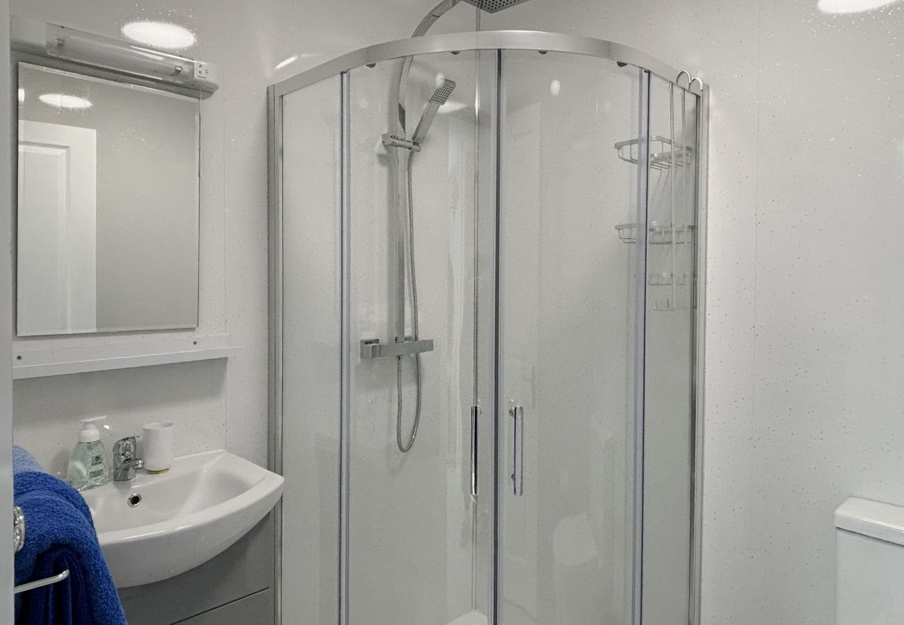 Clifden Holiday Apartment. Modern walk in shower, bright clean toilet and sink. with mirror. Contemporary style.