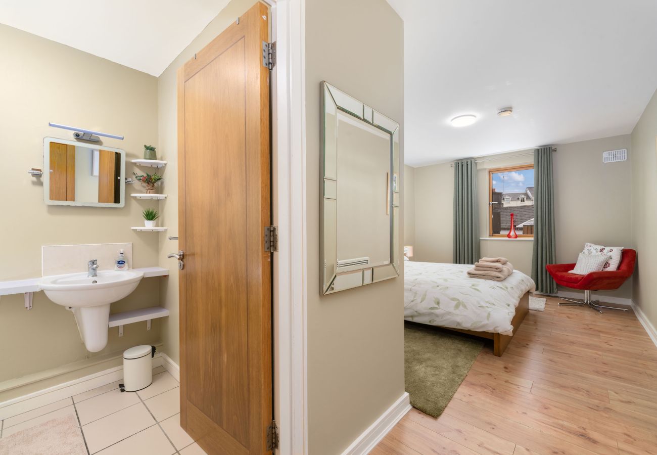 Clifden Town Apartment. View to king bed, wooden floors, en-suite. 