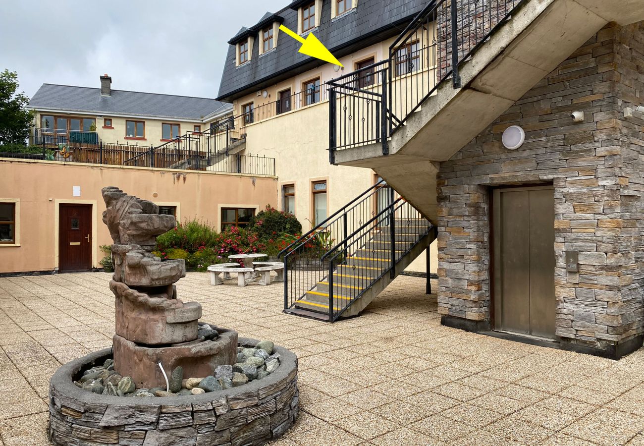 Clifden Town Holiday Apartment. Courtyard, stylish seating area, flowers. Stairwell and lift. 