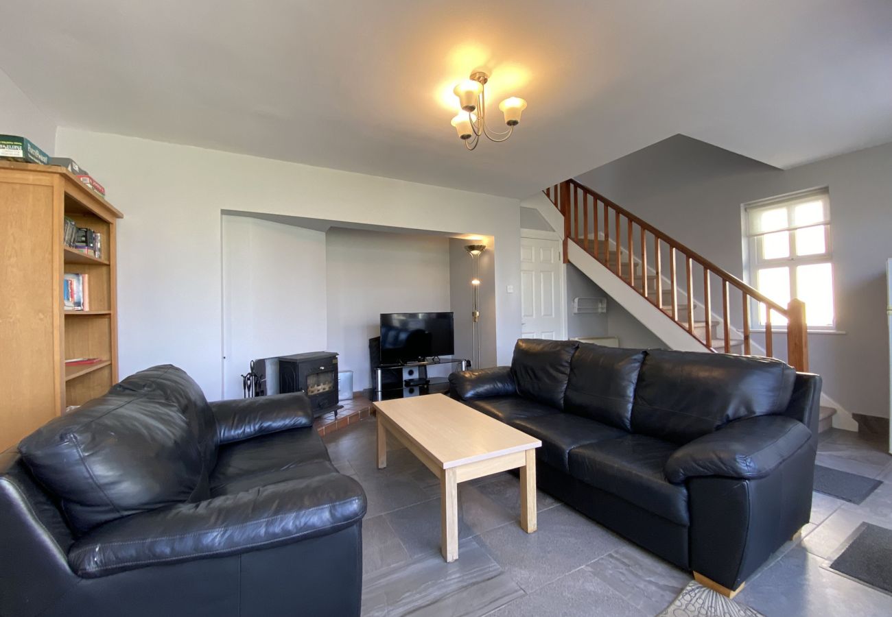 Clifden Glen Holiday Village No 58. Open plan dining, two comfortable sofas with stairwell. 